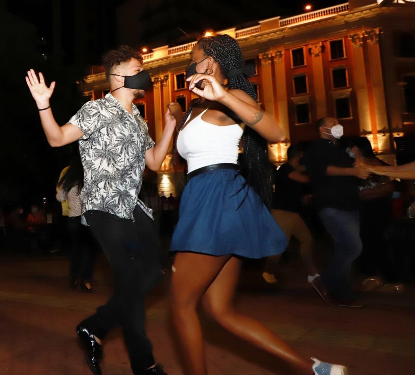 Personas bailando con tapabocas.