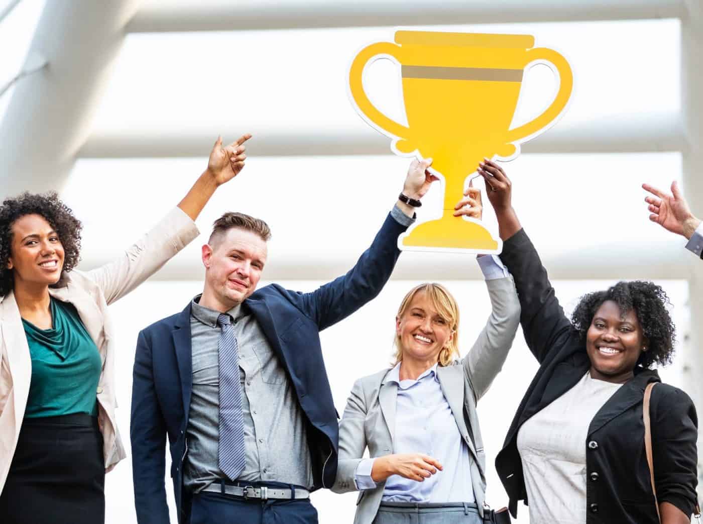 A group of people holding up a trophy
Description automatically generated
