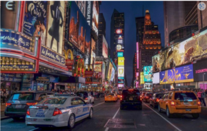 Times Square street with cars and buildings Description automatically generated